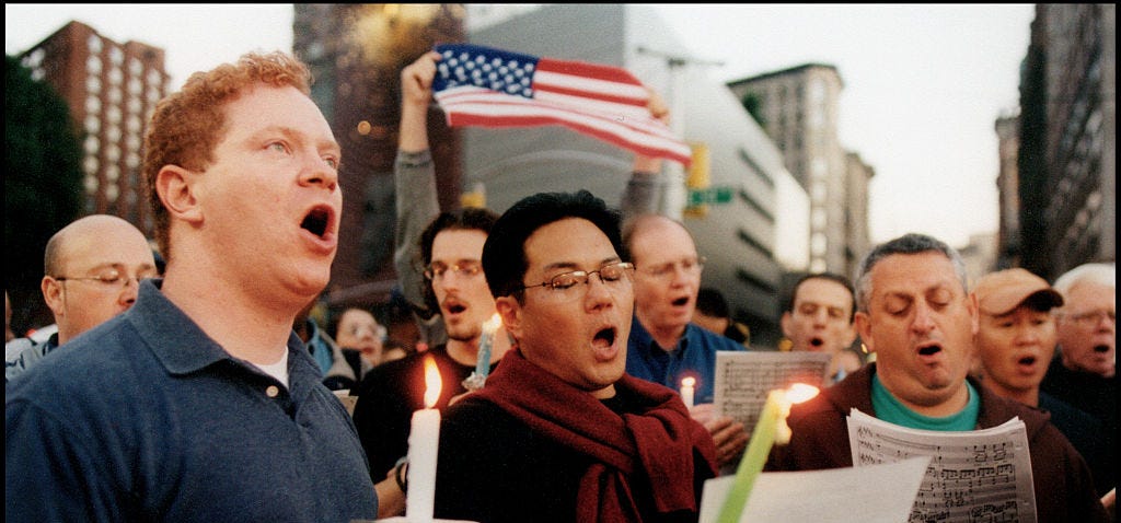 Men sing at a candlelight vigil for the victims of the September 11, 2001, terrorist attacks in New York City.